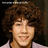 A person with curly brown hair and a light purple shirt appears in two side-by-side frames showing a subtle facial expression change.