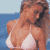 Pixelated image of a woman in a white bikini top against a blue water background with light blue sky.