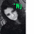 A grayscale photo of a person with long dark hair wearing a dark top, with green text above the head changing across frames.