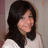 A static pixelated image of a person with long dark hair wearing a light-colored top against a muted background.