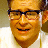Pixelated static image of a smiling man with glasses and light brown hair wearing a white shirt against a blurred background.