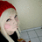 Pixelated image of a person with light hair wearing a red hat and black top, set against a muted background.
