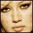 Pixelated close-up of a human face with light skin tone, dark brown eyes, and subtle makeup including eyeliner.