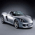 Pixelated silver convertible car with dark interior, angled left on gradient background.