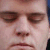 A pixelated close-up of a person's face showing eyes, nose, and mouth with closed eyes and neutral expression.