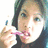 A pixelated image of a person holding a pink object near their mouth, surrounded by green text on a black background.