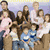 A group photo of multiple people with overlaid text listing names and "plus 8!" in a