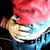 Pixelated close-up of a figure with red hair and light skin, wearing blue clothing against a dark background.