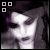 Pixelated grayscale image of a person's face with dark hair, three white squares in the top-left corner, and no visible text.
