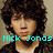 Pixelated portrait of a person with curly brown hair wearing a dark jacket over a light shirt, with cyan text overlays on a beige background.