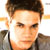 Static 50x50 pixel icon showing a close-up of a person's face with brown hair and light skin, wearing dark clothing against a bright background.