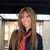 A pixelated image of a person in school uniform with red tie, dark jacket, blue skirt, and knee-high boots.