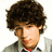 Pixelated portrait of a person with voluminous dark brown curly hair, light skin tone, and visible facial features including eyes, nose, mouth, and beard stubble.