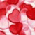 A static image of multiple overlapping red heart shapes on a light pink and white gradient background.