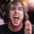 Pixelated image of a person with light brown hair and open mouth, next to purple text on black background.