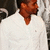 A person in a white shirt with a small dark logo on the chest, shown in three views with slight head and body position changes against a dark background with light patterns.
