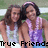 Two people in sleeveless tops stand close together with arms around each other against a blurred green and white background, with text at the bottom.