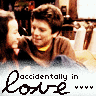 Static 96x96 pixel icon featuring a cartoon-style image of two people in an embrace with text overlay reading "accidentally in love" and four heart symbols.