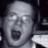 Pixelated grayscale static image of a human face with exaggerated features and open mouth, likely intended as an animated or expressive buddy icon.