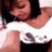 A person with dark hair wears a white top with black text and a black bottom, shown in four with slight pose changes
