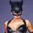 Pixelated static image of a character in black cat-themed costume with mask and ears, red lips, and partial chest visible against solid background.