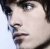 Pixelated close-up of a person's face showing eyes, nose, mouth, and dark hair against light background.
