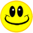 Yellow circular smiley face with black eyes and curved mouth on white background, next to pixelated text on yellow background.