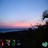 Pixelated static image of a sunset over water with dark landmasses below and blue sky above.