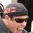 Static 48x48 pixel icon showing a close-up of a person's face with dark hair and sunglasses, rendered in low-resolution pixel art style with visible dithering and color blending.