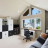 Pixelated static image of a modern house with large windows and dark furniture visible through them.
