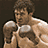 A pixelated animated sequence shows a shirtless man with brown hair in boxing gloves, cycling through three poses against a dark background while text overlays change.