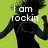 A pixelated image of a person in black clothing against a bright green background with white text reading "i am rockin" and "so, u be rockin 2".