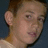 A pixelated image of a person with short brown hair, showing two side-by-side views with slight facial expression changes and text overlay.
