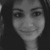 Grayscale pixelated portrait of a person with dark hair, neutral expression, and visible eyes, nose, and mouth against a dark background.