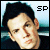 Pixelated static image of a person's face with dark hair and light skin, featuring the text "SP" in the top-right corner against a blue gradient background.