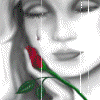 A grayscale portrait of a woman with closed eyes holding a rose that changes color , with a single tear visible on her cheek