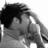Pixelated grayscale image of a person with dark hair wearing a light-colored shirt, viewed from the side.