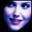 A pixelated face with blue-toned skin and dark hair, showing a smiling expression in the first frame followed by subtle mouth movements and heart-shaped cursor changes.
