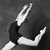 Black-and-white animated contact sheet showing two frames of a gymnast performing a split on a balance beam with arms raised and legs extended in opposite directions.