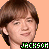 Pixelated close-up of a person with brown hair against an orange background, featuring green and white text reading 'JACKSON' at the bottom.
