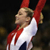 Pixelated image of a person in white and red athletic attire with arms raised, set against dark background.