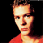 Pixelated static image of a person's face and upper torso in red clothing against black background, rendered with dithering and color blending.