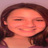 A static pixelated image of a person with closed eyes and a broad smile, dark hair, and a light-colored top against a muted background.