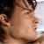 Pixelated close-up of a person's face in profile view with dark hair and light skin tone.
