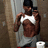 A pixelated figure in a white tank top and gray shorts stands against a textured wall, holding a phone to their ear.