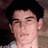 Static pixelated image of a person's face with dark hair and light skin, cropped to show upper head and shoulders against a blurred background.