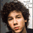 A static image of a person with curly brown hair in three distinct poses: eyes closed, eyes open looking left, and wearing sunglasses.