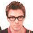 A pixelated image shows a person with short brown hair and glasses on the left, next to four people standing in a on the right, with yellow text reading 'Weezer' below