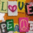 A static collage of letter and symbols on a yellow-orange background with white, green, pink, black, and brown elements