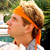Pixelated static image of a person with orange headband and brown hair against green background, likely from Malibu's Most Wanted 29 series.